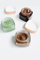 Assortment of different jams in small jars on white background, top view