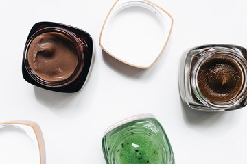 Assortment of different jams in small jars on white background, top view