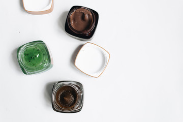 Assortment of different jams in small jars on white background