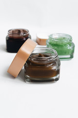 Assortment of different jams in small jars on white background, top view