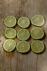 sliced limes on wood background