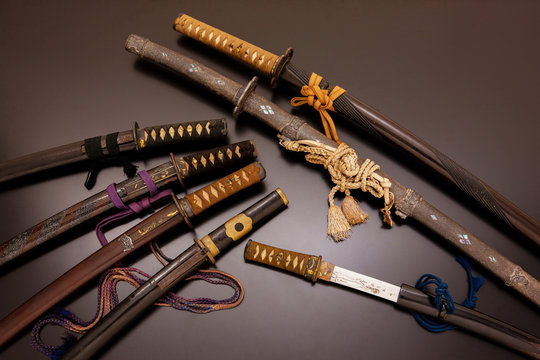 Collection of traditional Japanese swords and scabbards on a dark background