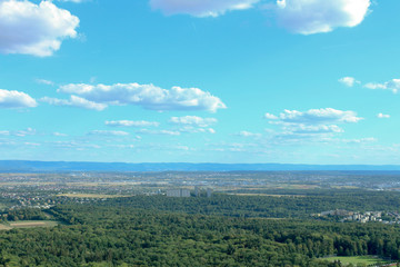 Amazing Landscape view on the beautiful forests, alpine mountains and idyllic fields of South Germany with a blue sky before sunset with clouds