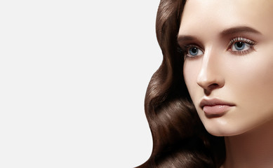 Glamour Woman with Fresh Daily Make-up on White. Wavy Hairstyle. Shiny Hair, smooth clean Skin, natural Makeup eyebrows