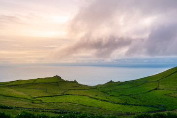 A mount during a sunset with blue sky green fields and some clouds