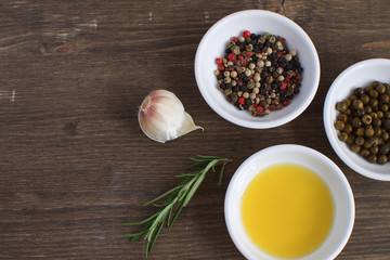 Olive oil porcelain plate Rosemary branch Pepper mix Garlic Seasoning Spices Cooking concept Wooden background Top view Copy space Flat lay