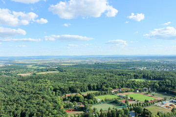 Amazing Landscape view on the beautiful forests, alpine mountains and idyllic fields of South Germany with a blue sky before sunset with clouds