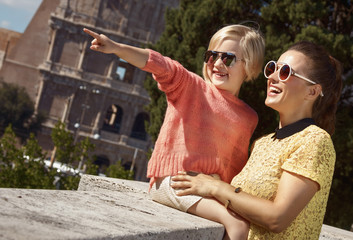happy mother and daughter travellers pointing at something