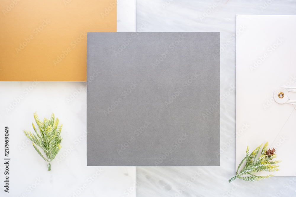 Poster Top view of blank grey card overlap on envelop and gold card with pine leaf on two layer step of marble table top.Mock up template for display of design .luxury business items.