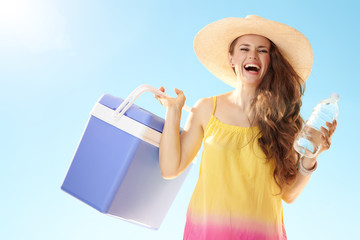 woman with blue plastic cooler box and bottle of cold water
