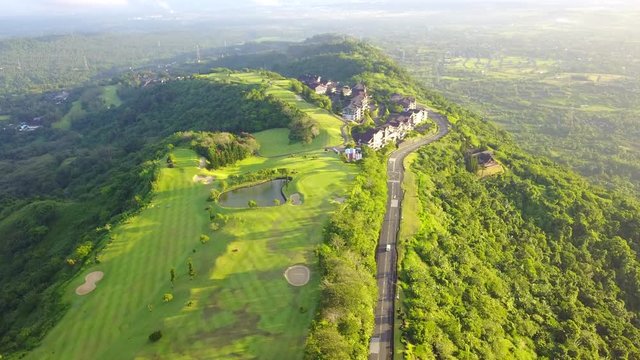 aerial shot of a golf course on top of a mountain with view of the horizon