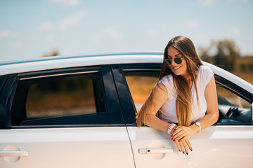 Woman posing while leaning on the car window.