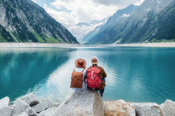 Travelers couple look at the mountain lake. Travel and active life concept with team. Adventure and...
