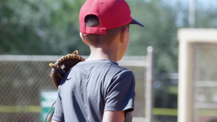 Slow motion of boy wearing baseball glove during practice and catching ball - Powered by Adobe