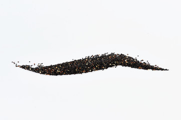 closeup of a pile of black quinoa seeds on a white background