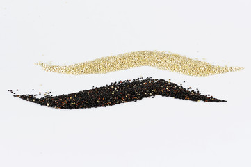 Grains of black and white quinoa isolated on white background.
