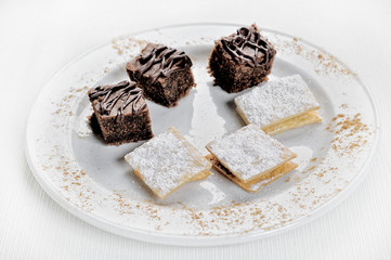 Delicious Chocolate Brownies and Alfajores. On a white background.