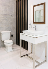 Fototapeta na wymiar Modern spacious bathroom with bright tiles with toilet and sink.