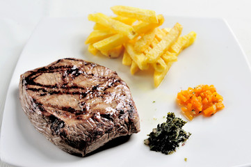 dish with grilled meat. Meat, French fries accompanied by chimichurri sauce