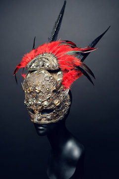 Golden mask with precious stones and feathers