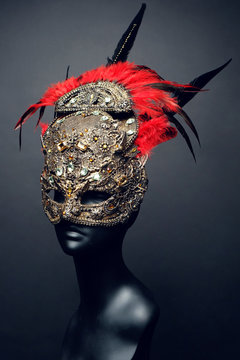 Golden mask with precious stones and feathers