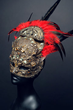 Golden mask with precious stones and feathers