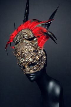 Golden mask with precious stones and feathers