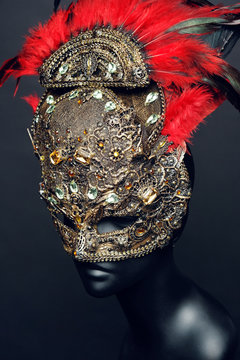 Golden mask with precious stones and feathers