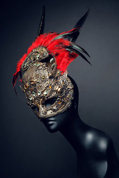 Golden mask with precious stones and feathers