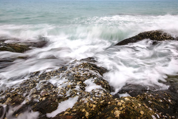 Sea waves crashing to rocks creating foam