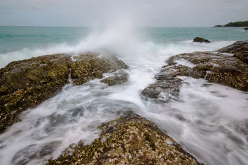 Sea waves crashing to rocks creating foam