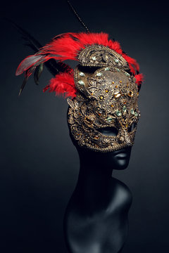 Golden mask with precious stones and feathers