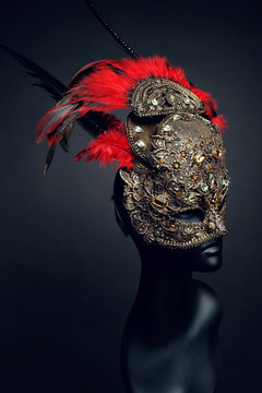 Golden mask with precious stones and feathers