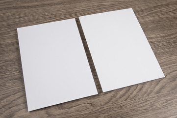Blank flyer poster on wooden background to replace your design.