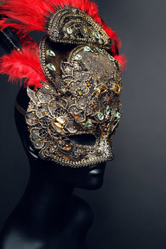 Golden mask with precious stones and feathers