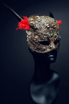 Golden mask with precious stones and feathers