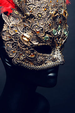 Golden mask with precious stones and feathers
