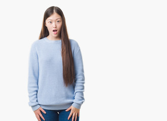 Young Chinese woman over isolated background afraid and shocked with surprise expression, fear and excited face.