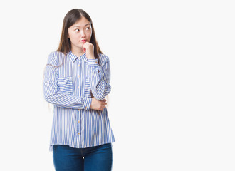 Young Chinese woman over isolated background with hand on chin thinking about question, pensive expression. Smiling with thoughtful face. Doubt concept.