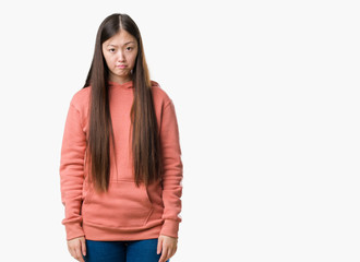 Young Chinese woman over isolated background wearing sport sweathshirt depressed and worry for distress, crying angry and afraid. Sad expression.