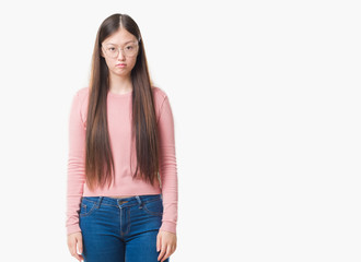 Young Chinese woman over isolated background wearing glasses depressed and worry for distress, crying angry and afraid. Sad expression.