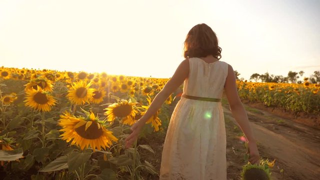 little girl running across the field with sunflowers at sunset. slow motion video. girl runner in the field at sunset sunflowers. lifestyle girl sunlight runs the concept of sunflowers