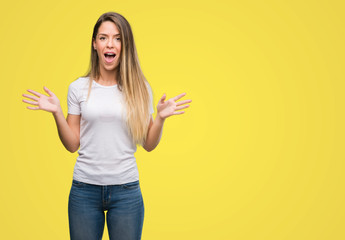 Beautiful young woman wearing t-shirt and jeans scared in shock with a surprise face, afraid and excited with fear expression