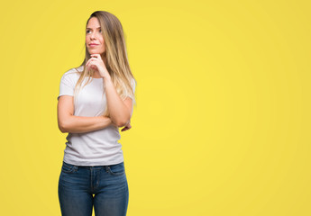 Beautiful young woman wearing t-shirt and jeans serious face thinking about question, very confused...