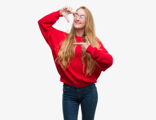 Blonde teenager woman wearing red sweater smiling making frame with hands and fingers with happy face. Creativity and photography concept.