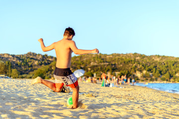 Obraz na płótnie Canvas Kid playing with the ball on the beach