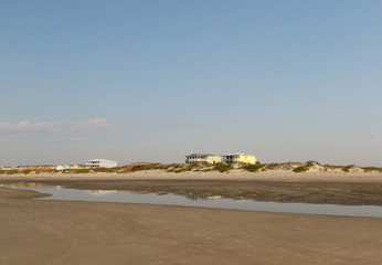 Luxury beach houses on the Atlantic Ocean, seen across an empty beach at sunrise, Sunset Beach, North Carolina