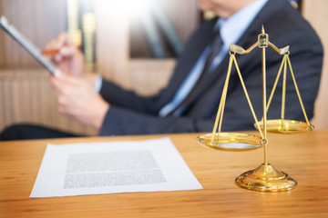 lawyer judge reading documents at desk in courtroom working on wooden desk background. gavel  golden Weight. and soundblock of justice.