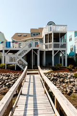 Long wooden dock leading to a luxury vacation rental beach house on Sunset Beach, North Carolina