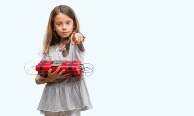 Brunette hispanic girl holding a bomb pointing with finger to the camera and to you, hand sign, positive and confident gesture from the front